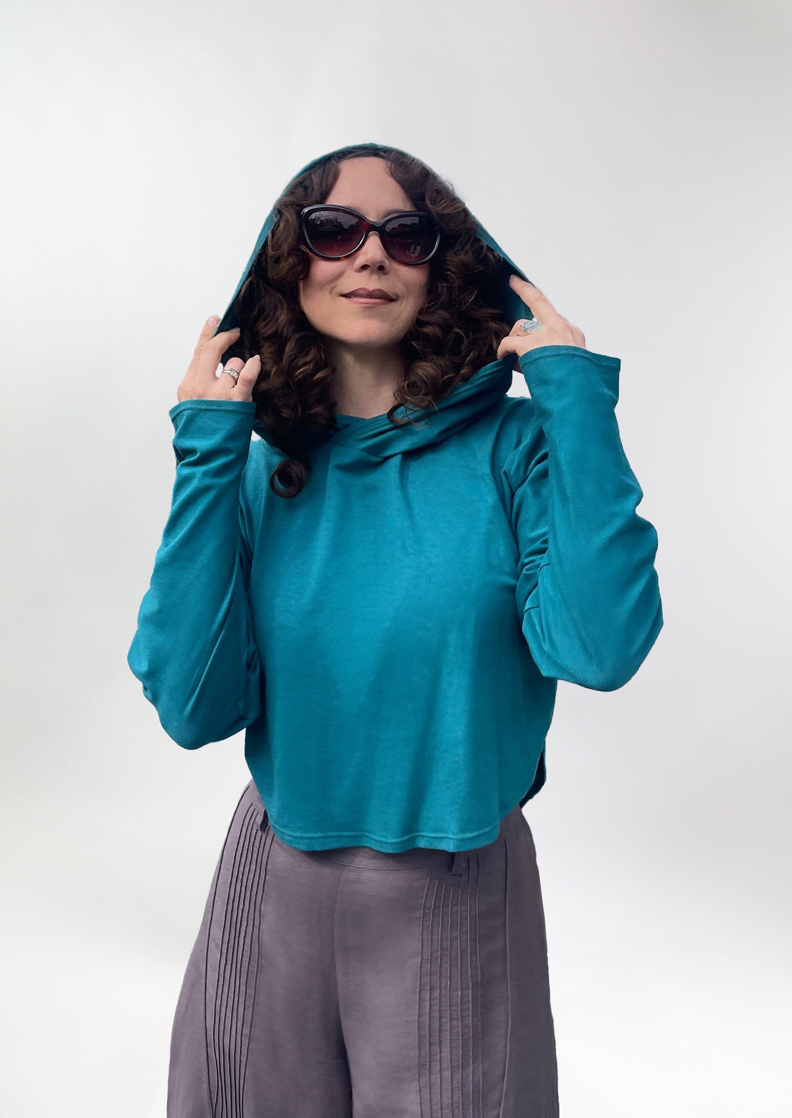 Woman in sun safe upf 50+ hoodie for travel , with extra large hood and glovelettes for hand protection,