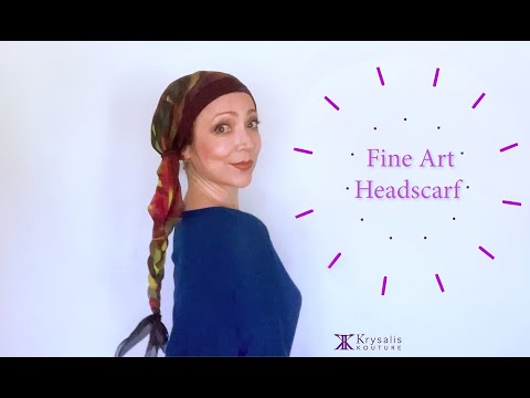 A woman in a blue blouse shows us how to wear and tie the exquisite Krysalis Kouture Fine Art Headscarf. It can be styled and worn in over 20 different ways
