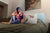 Woman sitting up in bed, looking lovey in her medically accessible adaptive wear outfit, which is scan ready and can get a chest port infusion in