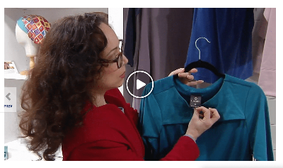 Paloma the founder of LuxCare Clothing showing off the adaptive wear garment tags