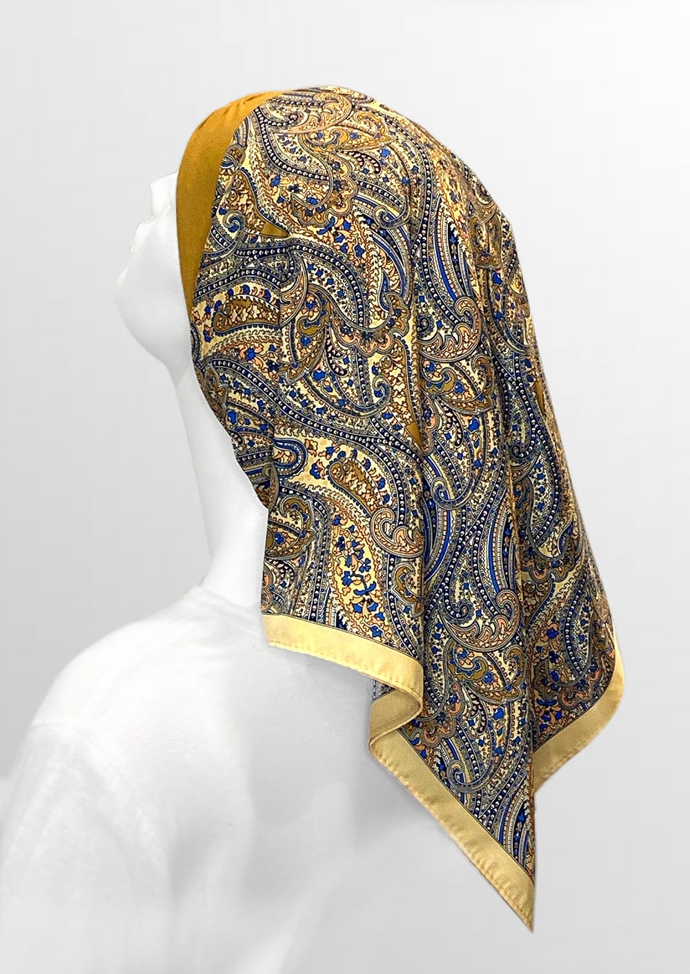 beautiful woman wearing a fashionable headscarf, of gold and paisley, in the retro kerchief style, designed specifically for those experiencing hair loss