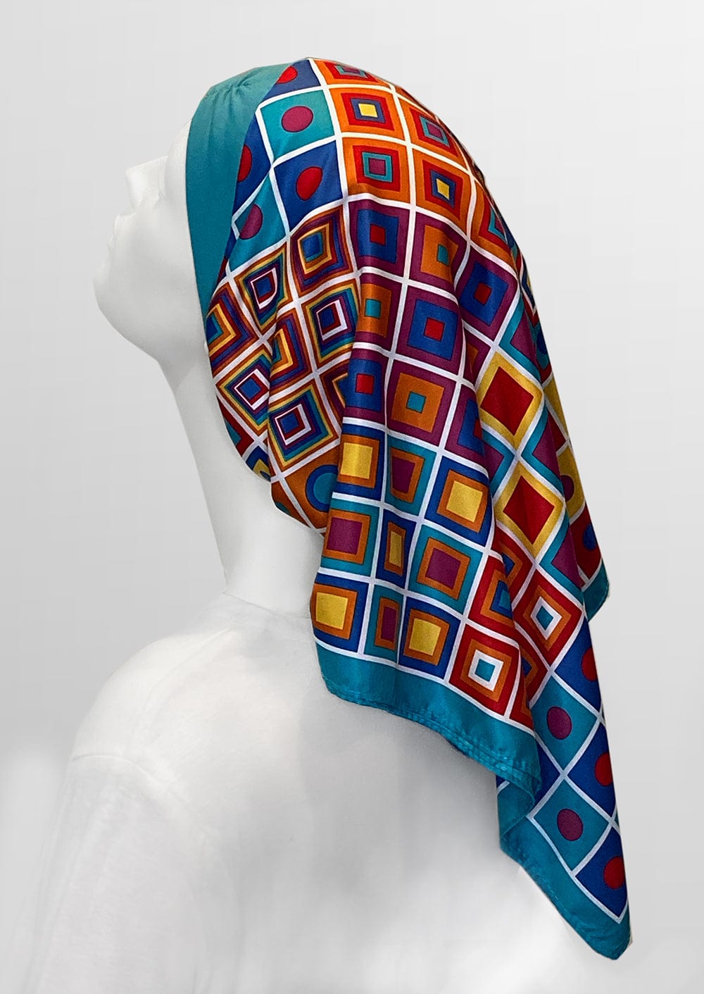 Fashionable headscarf, of teal  headband and matching and multi color geometric shapes , in the retro kerchief style, designed specifically for those experiencing hair loss.