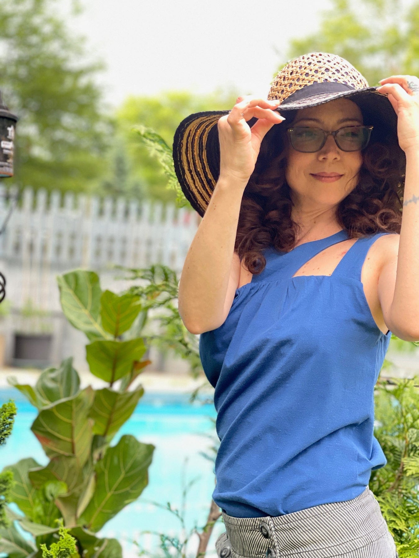 Woman in medically adaptive fashion for cancer patients and treatment accessible, blue tank top with chest posrt access 